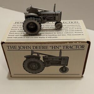 Spec Cast pewter John Deere model HN tractor.  With original packaging.